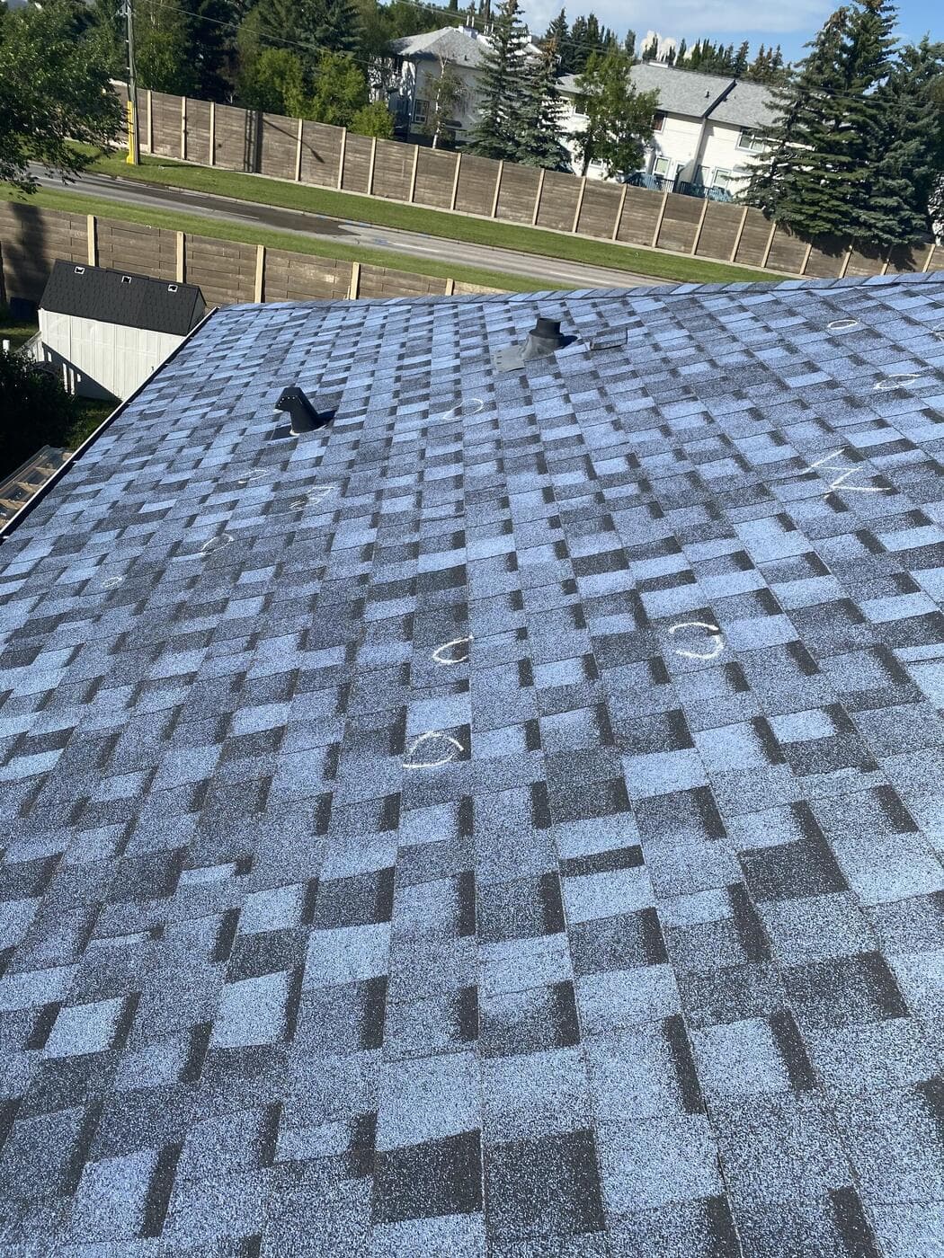 A Calgary roof slope with multiple hail impacts circled in chalk
