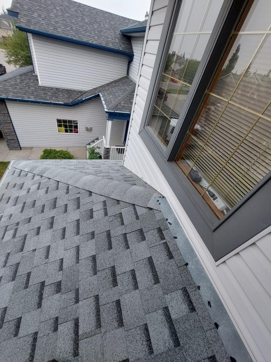 Step flashing where a Calgary roof slope meets a wall