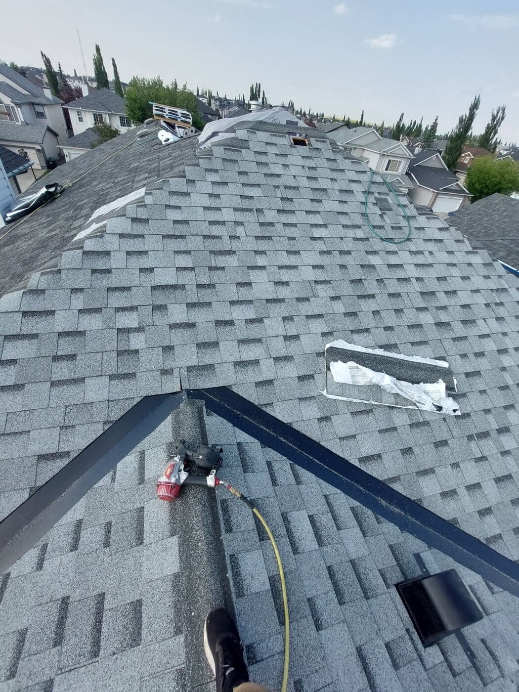 New architectural shingles being laid over synthetic underlayment on a Calgary roof