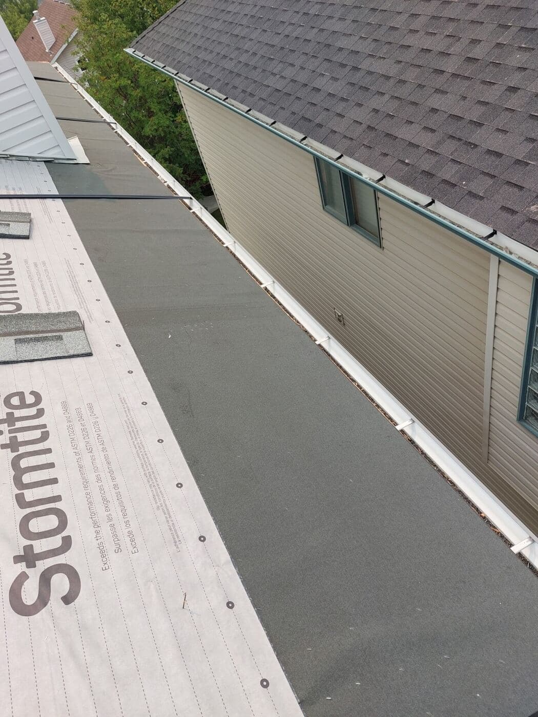 IKO Stormtite synthetic underlayment run up to a wall transition before shingles go on
