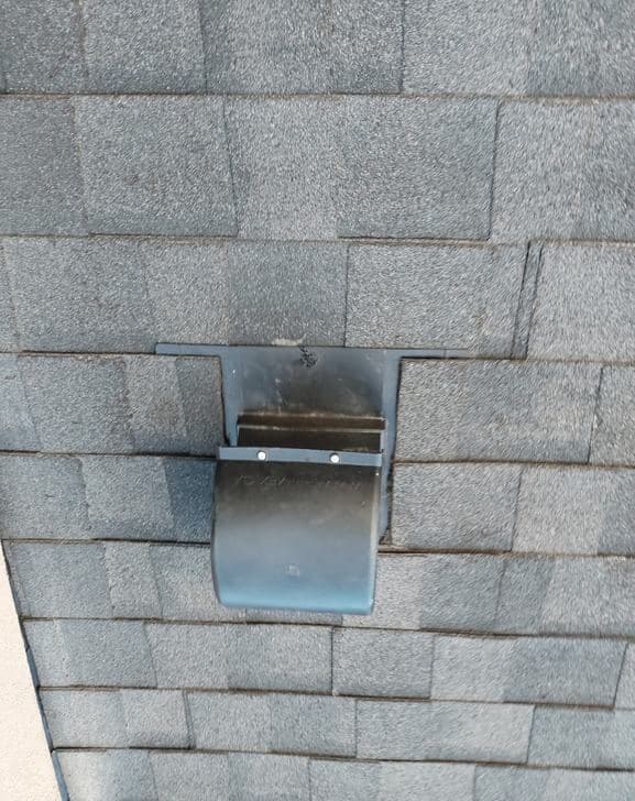 New vent flashing set into the shingle courses on a Calgary roof